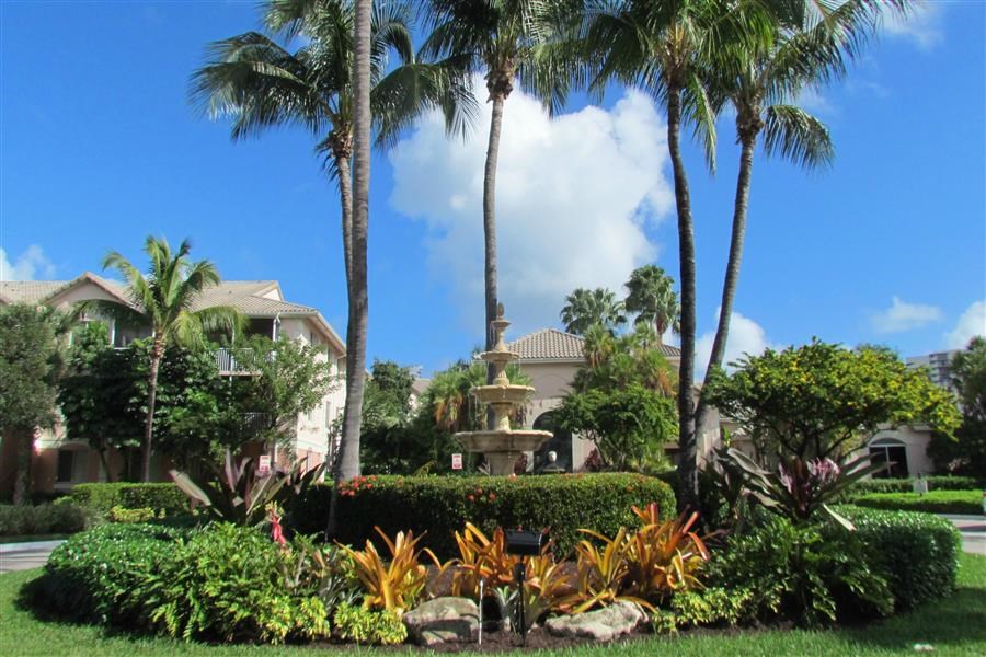 a fountain in a garden in front of a house