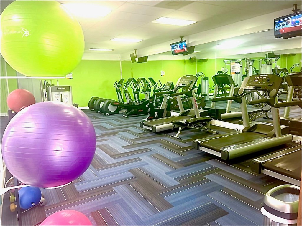 a gym with a bunch of exercise equipment and balloons
