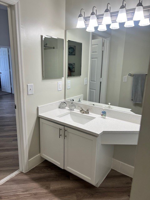 A white bathroom vanity with a mirror and lights above it.
