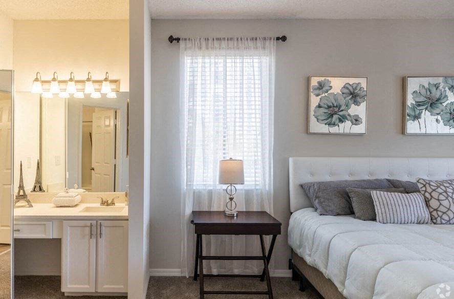 a bedroom with a bed and a bathroom with a sink