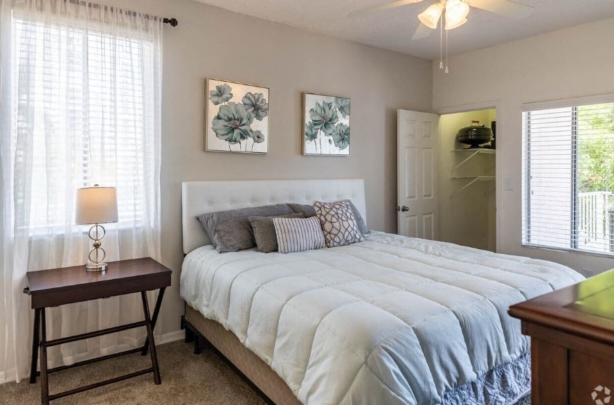 a bedroom with a large white bed and a table