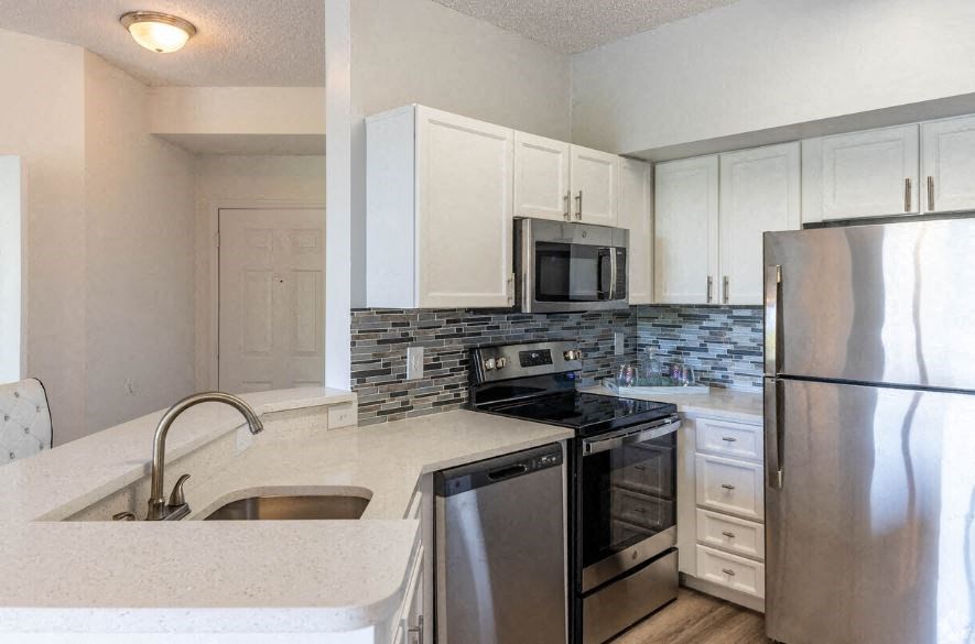 a kitchen with stainless steel appliances and white cabinets