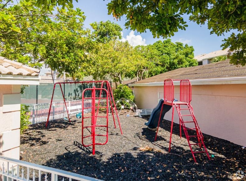 a play set in a yard next to a house
