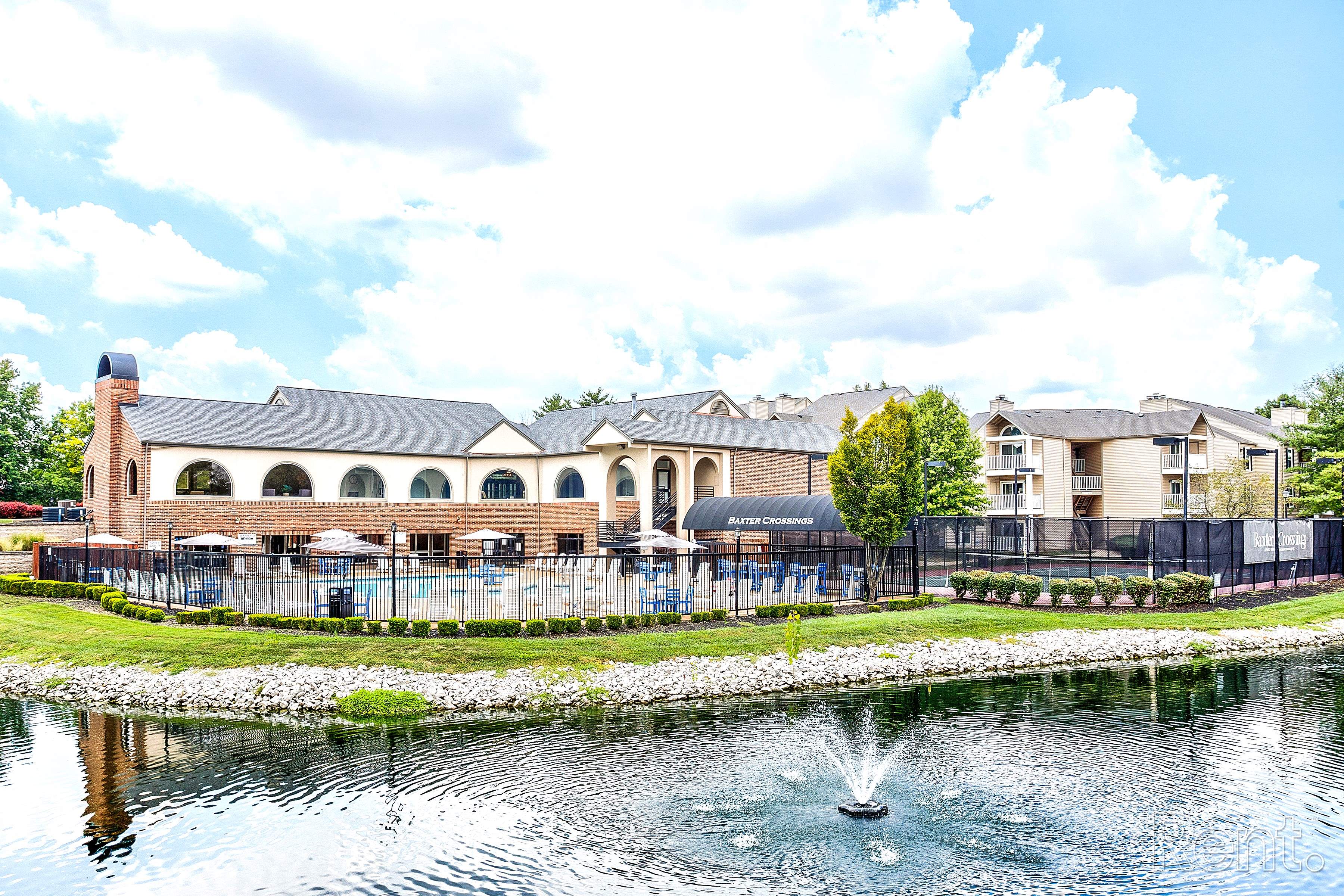 a fountain in a pond with a building in the background
