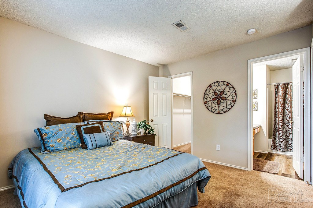 the master bedroom has a large bed and a door to the bathroom