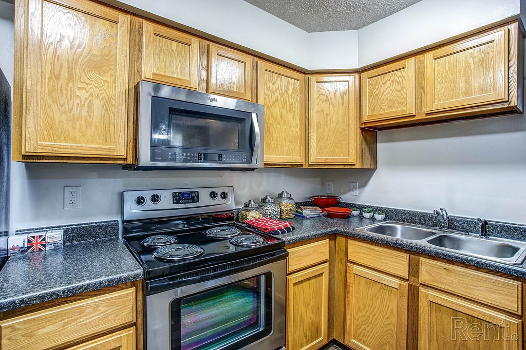 a kitchen with stainless steel appliances and wooden cabinets