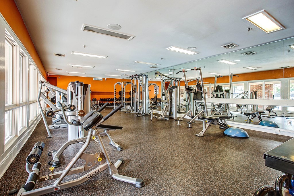 a gym with cardio machines and weights on the floor