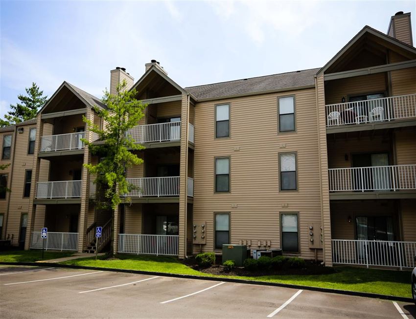 an apartment building with balconies and a parking lot