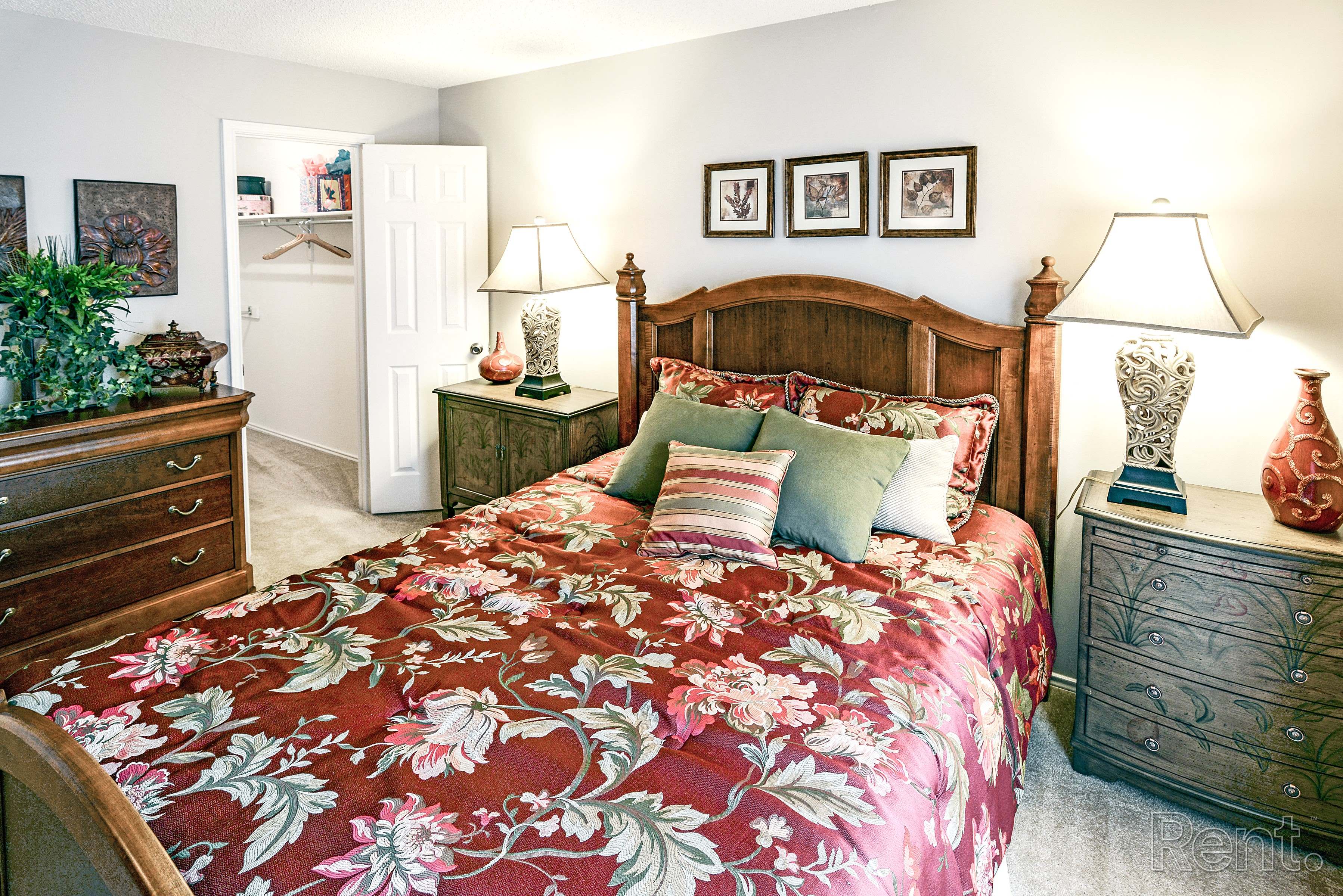 a bedroom with a bed and two dressers and a closet