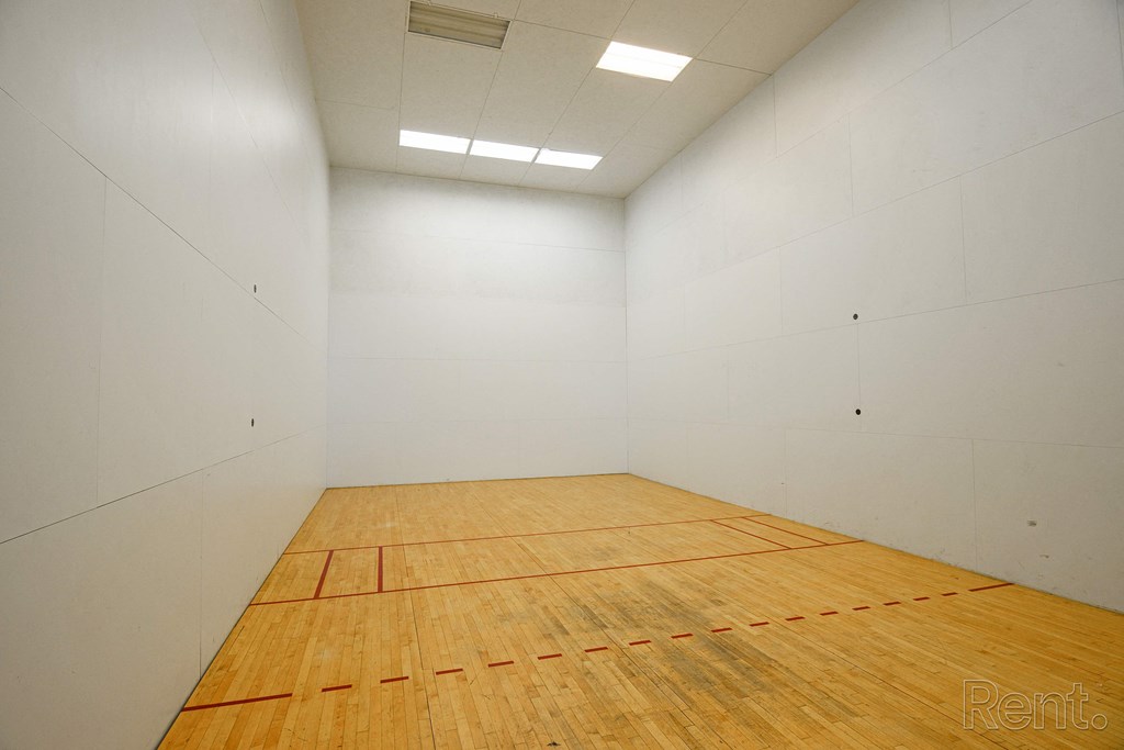 a racquetball court in a white room with a wooden floor