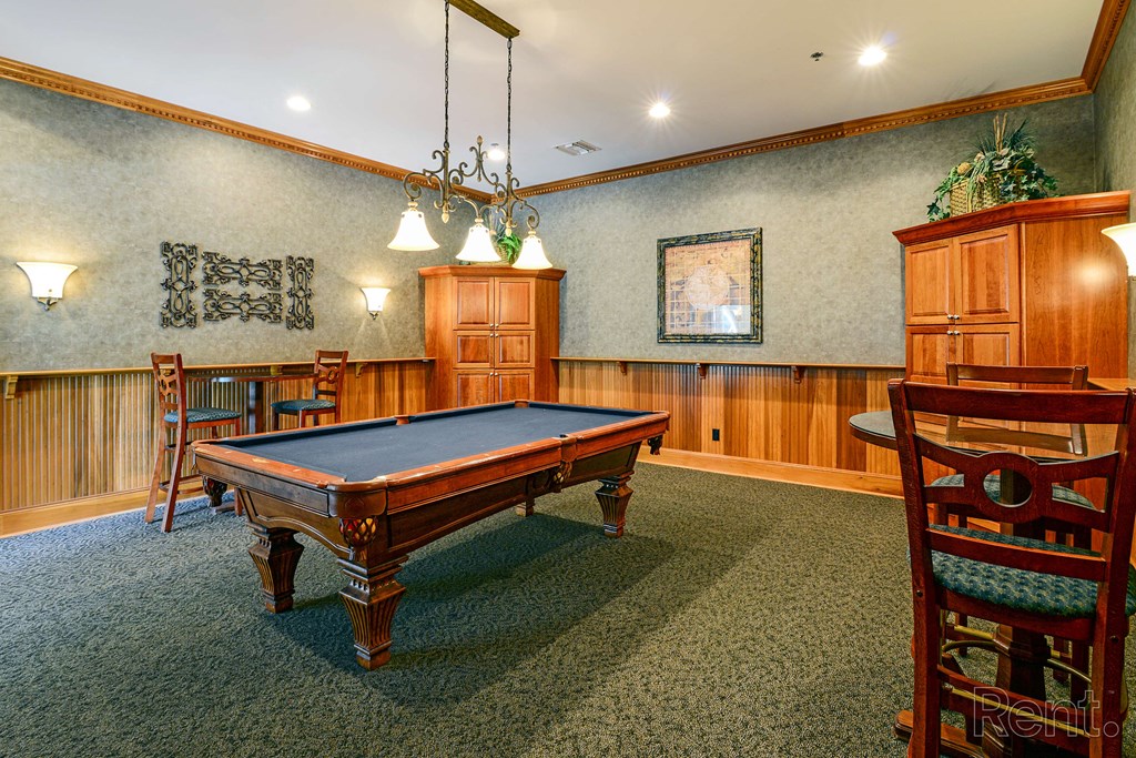 a game room with a pool table and chairs