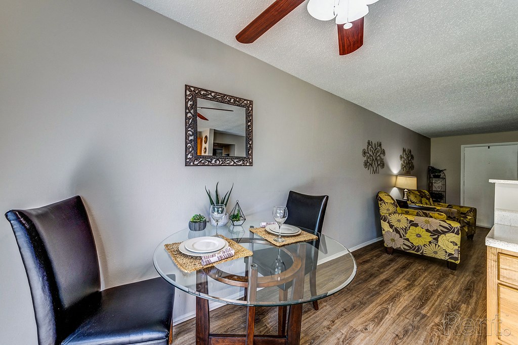 a dining room with a glass table and chairs