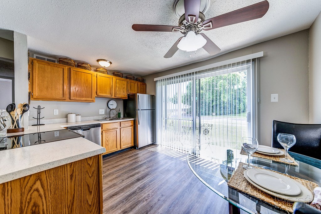 a kitchen and living room with a sliding glass door to a patio