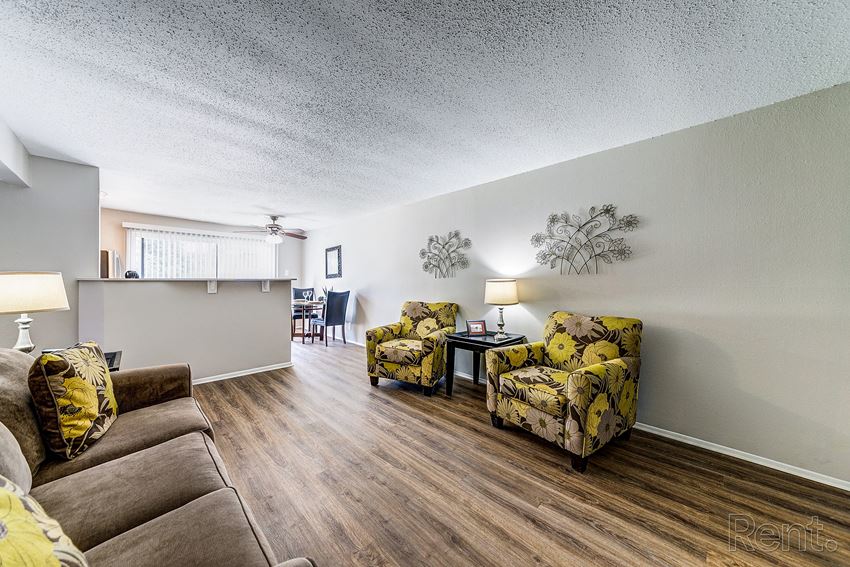 a living room with couches and chairs and a kitchen