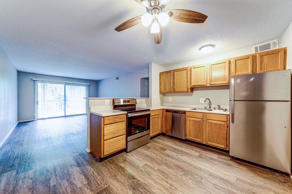 an empty kitchen with wooden cabinets and stainless steel appliances