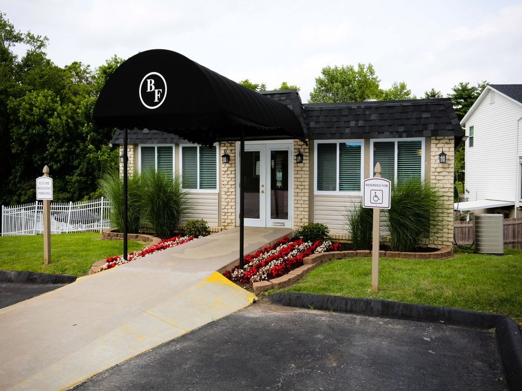 a small white house with a black awning in front of it