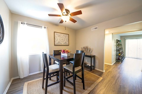 a dining room with a table and chairs and a ceiling fan