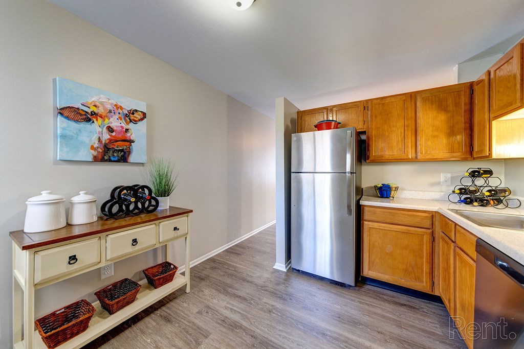 a kitchen with wooden cabinets and a stainless steel refrigerator
