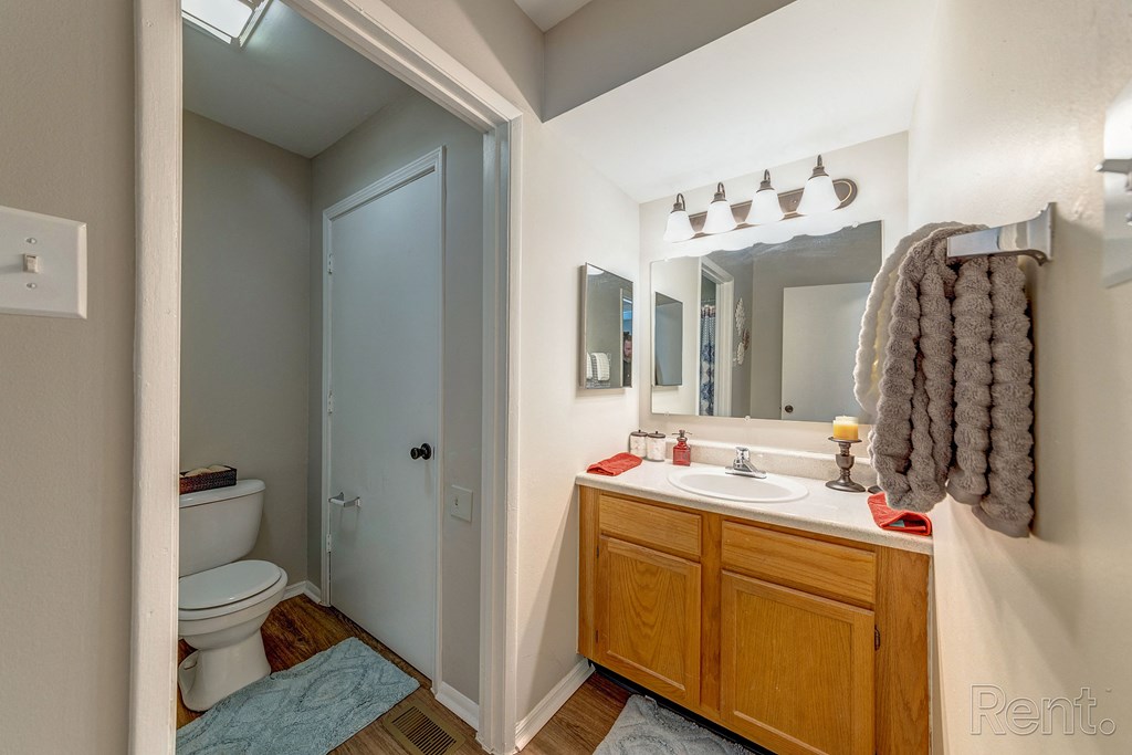 a bathroom with a toilet sink and mirror and a shower