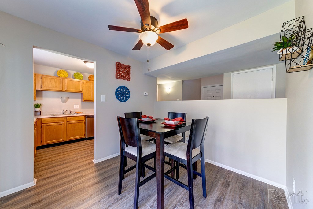 a dining area with a table and chairs and a ceiling fan