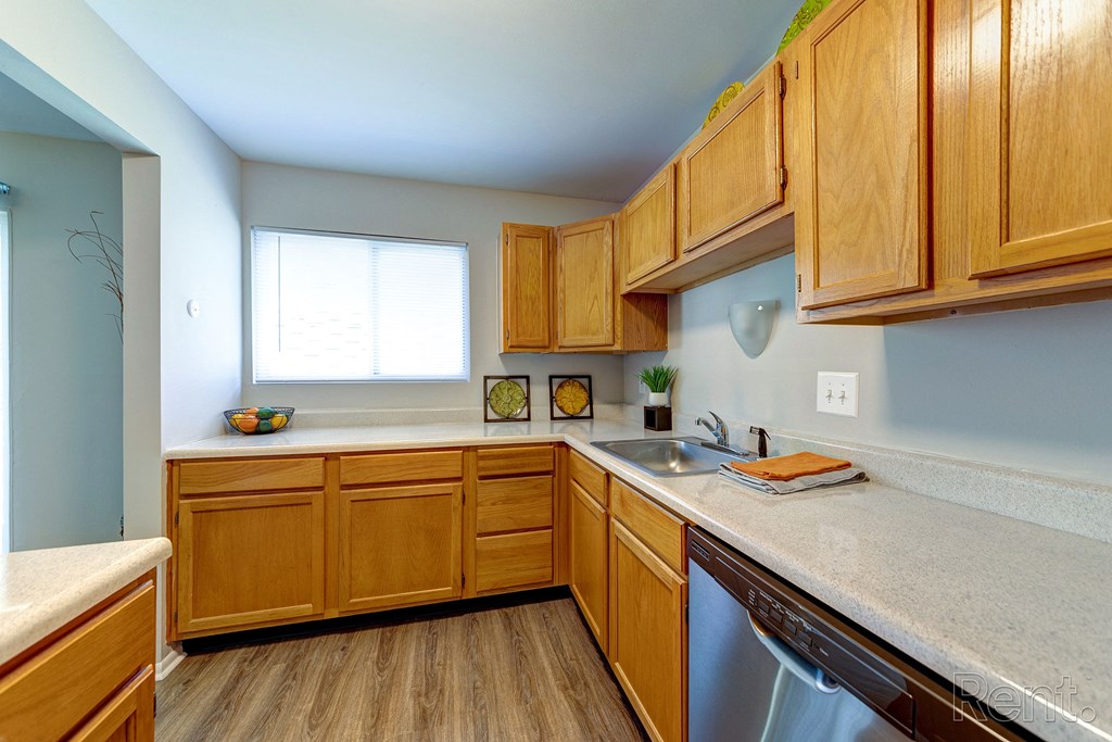 an empty kitchen with wooden cabinets and a sink