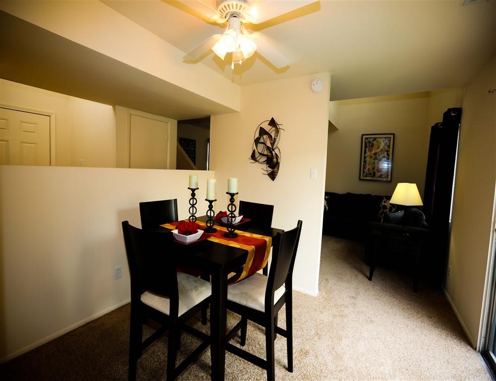 a dining room with a table and chairs and a ceiling fan