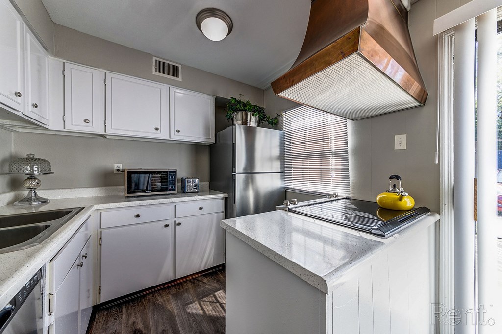 a kitchen with white cabinets and stainless steel appliances