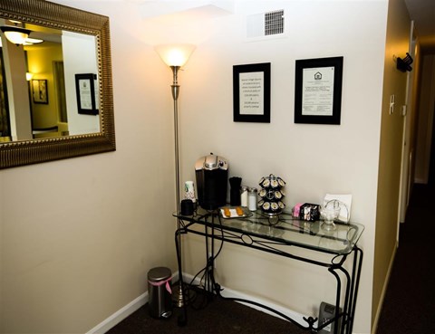 a corner of a room with a glass table with items on it