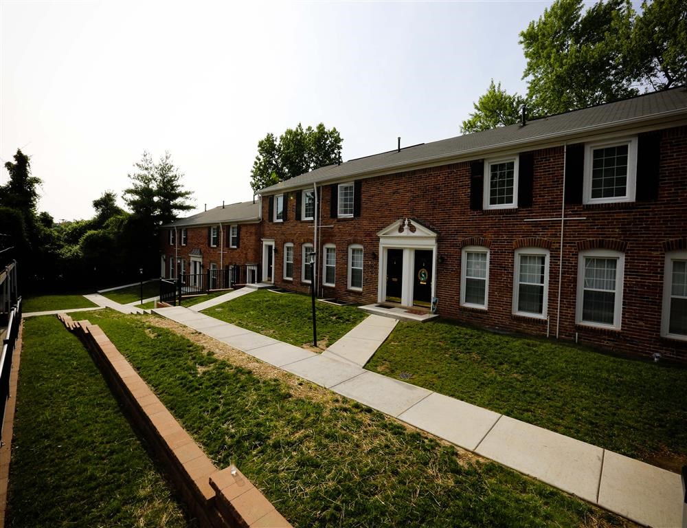an apartment building with a sidewalk in front of it