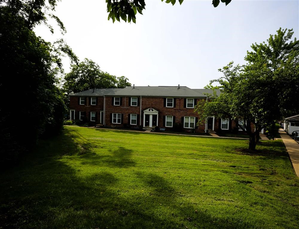 a large lawn in front of a brick building