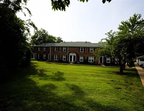 a large lawn in front of a brick building