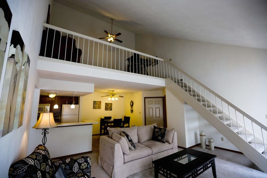 a living room with a couch and a staircase