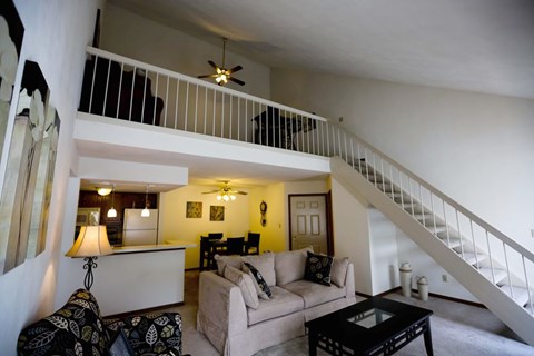 a living room with a couch and a staircase