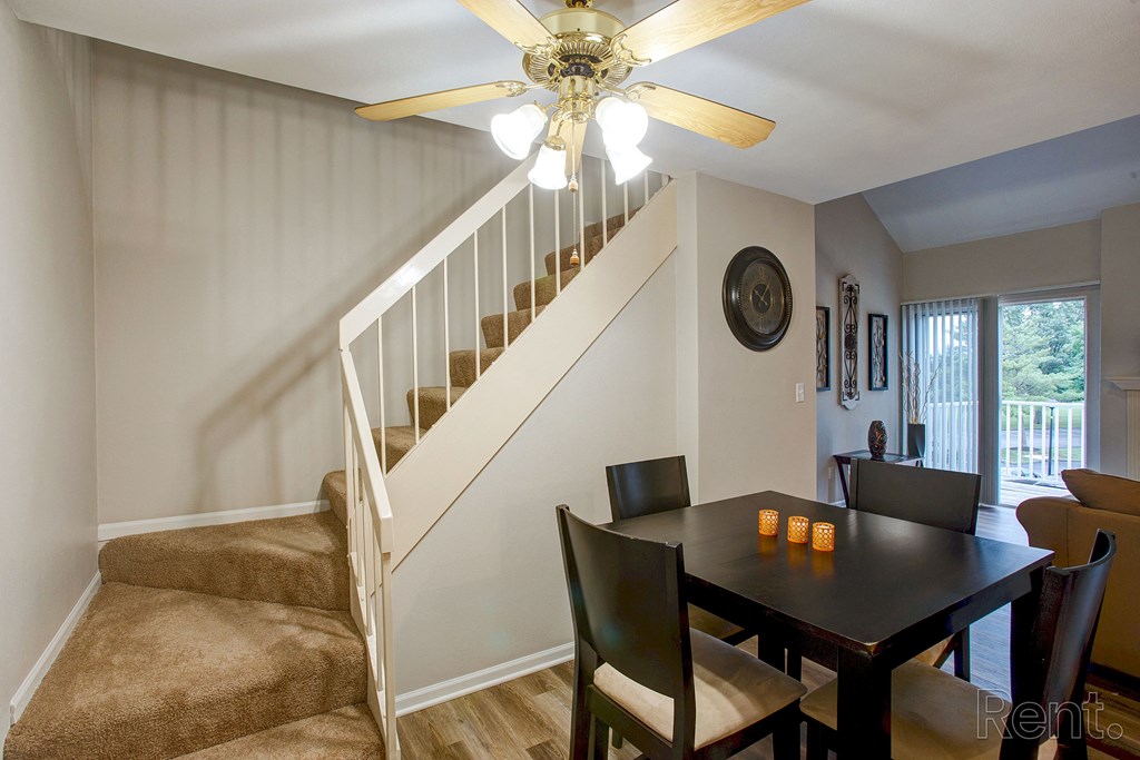 a dining room with a table and chairs under a staircase