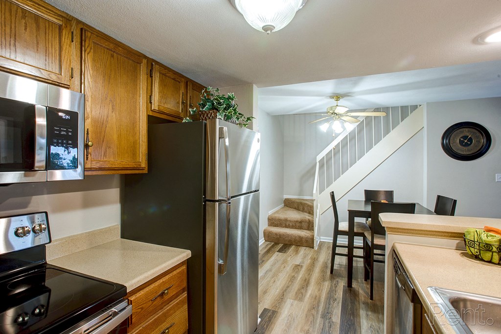 a kitchen with stainless steel appliances and a dining room with a staircase