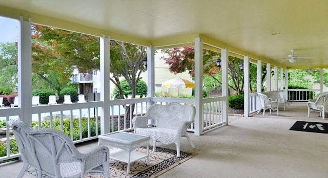 a screened in porch with chairs and tables