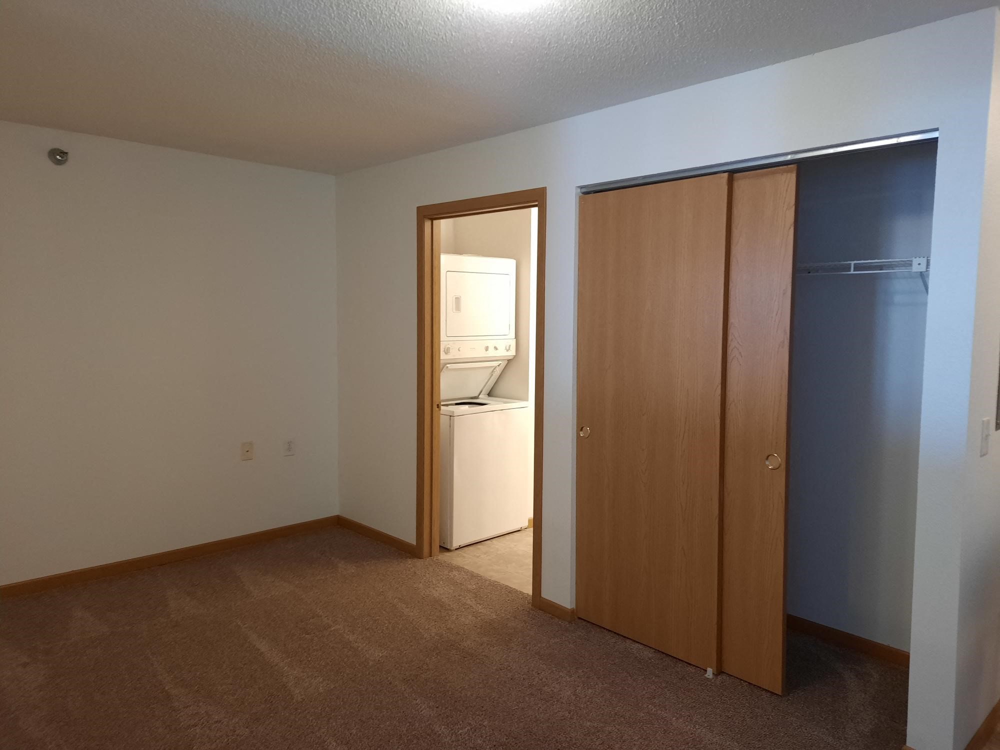 a bedroom with a door to a bathroom and a closet