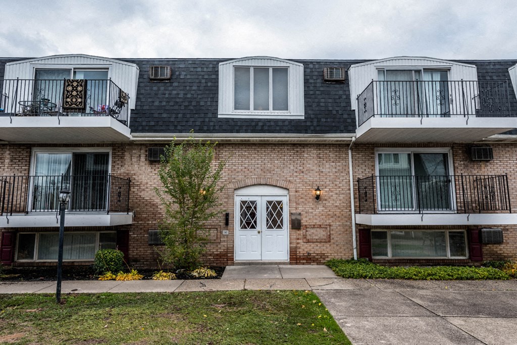 a brick apartment building with a white door and balconies