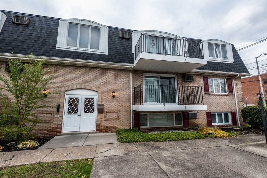a brick house with a balcony and a white door
