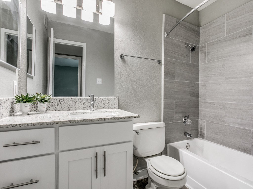 a bathroom with a toilet and a tub and a sink