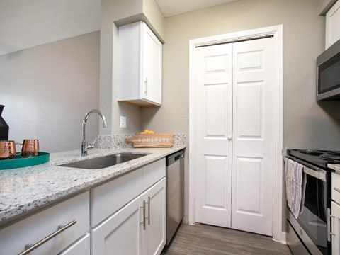 a kitchen with white cabinets and a sink and a refrigerator