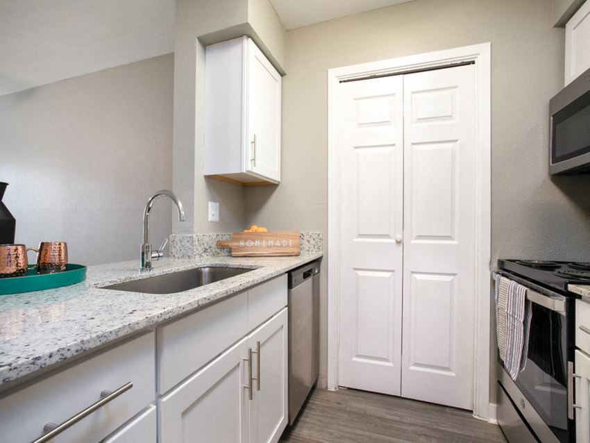 a kitchen with white cabinets and a sink and a refrigerator