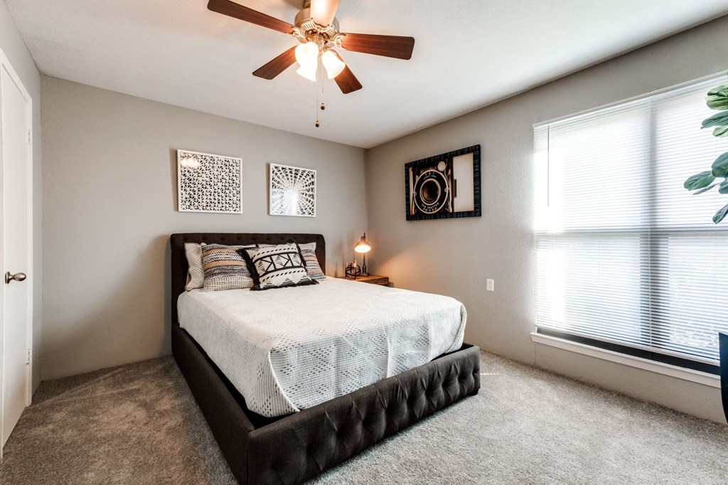 a bedroom with a bed and a ceiling fan