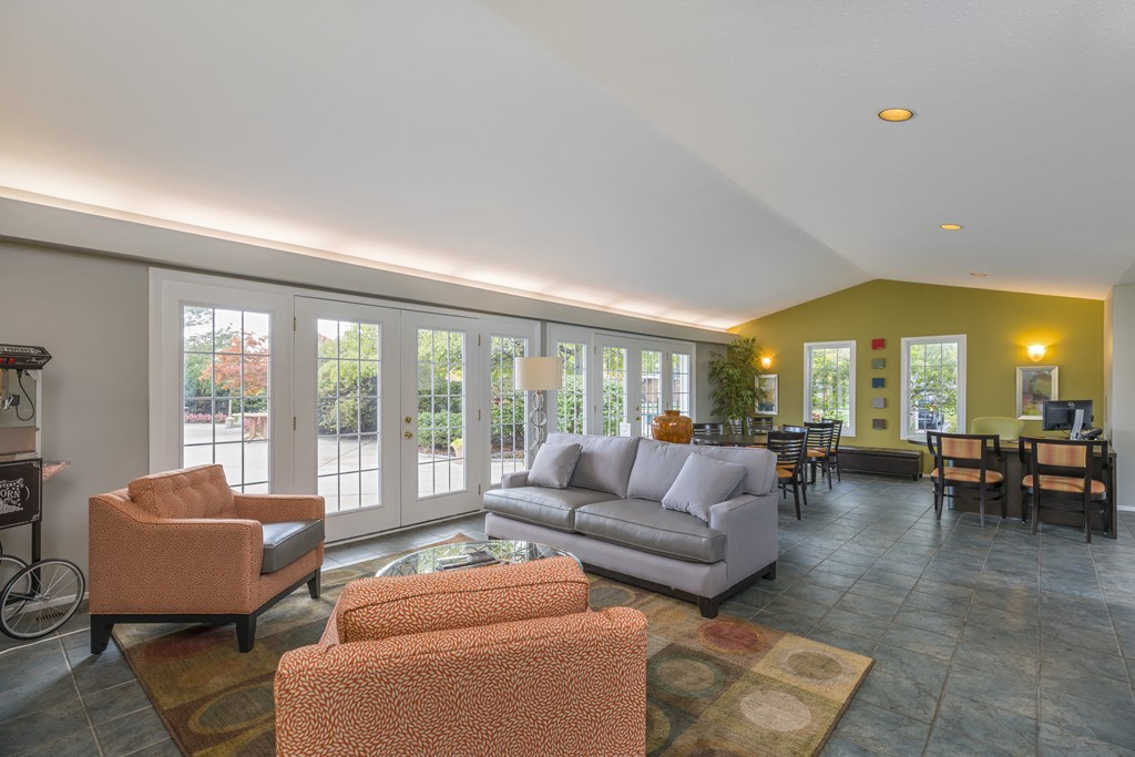 a living room with couches and chairs and a dining room with a patio