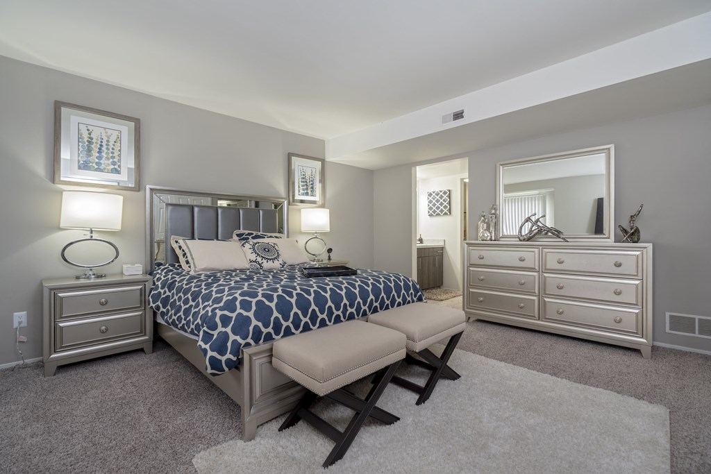 a bedroom with a bed and two dressers