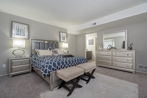 a bedroom with a bed and two dressers