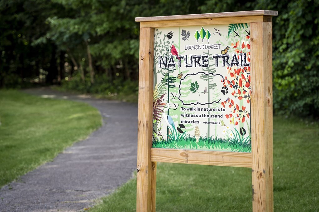 a sign for a nature trail on the side of a path