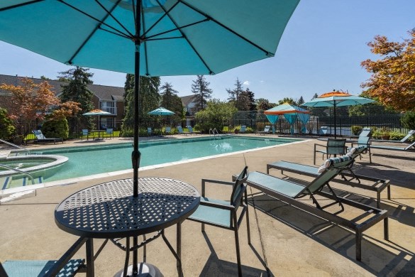 our apartments have a pool and patio with chairs and umbrellas