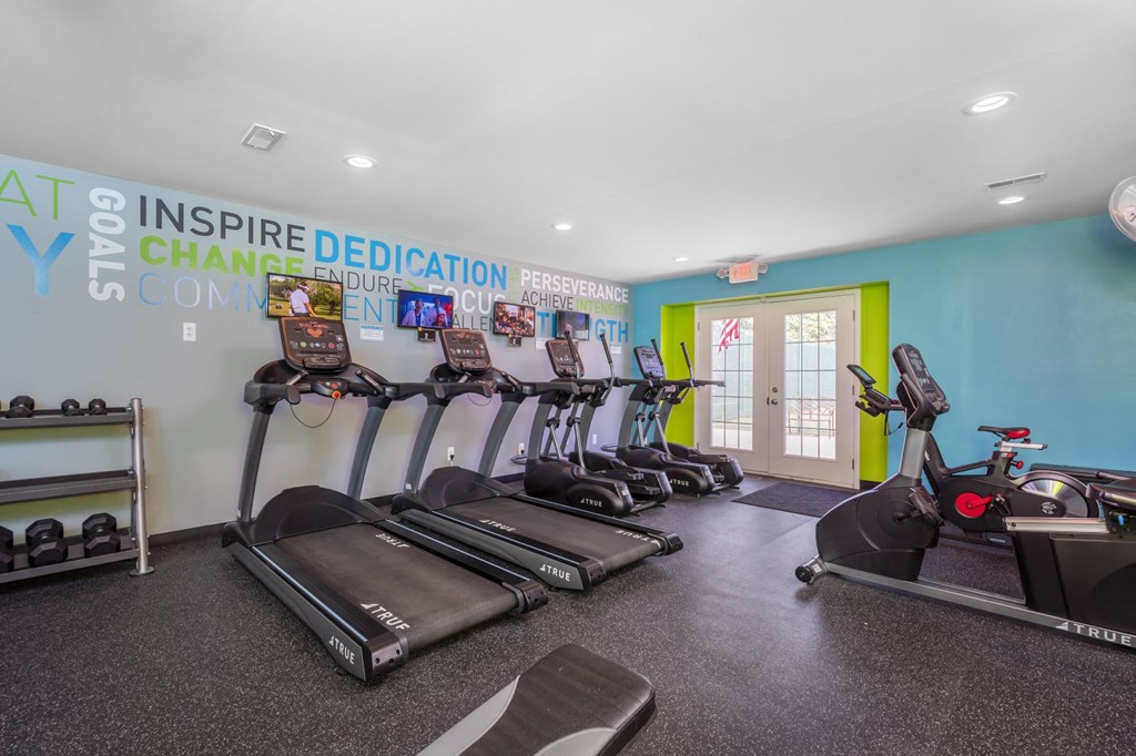 a gym with cardio equipment and weights in a building