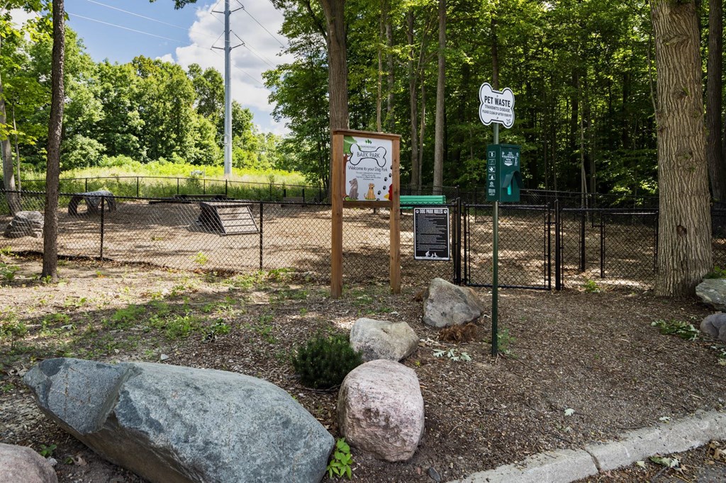 a dog park with rocks and a sign